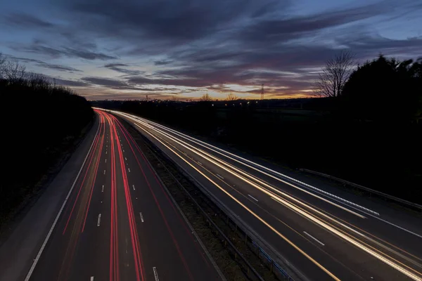 İngiltere'de otoyol, gün batımında, yolda trafik yarattığı hafif yollar ile