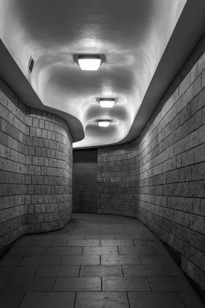 Londra şehrinde geceleyin, siyah-beyaz kavisli bir yaya tüneli (metro).