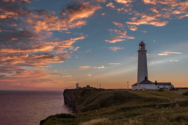 Nash Point Lighthouse at sunset. The lighthouse is in South Wales, on the Welsh Coastal Path.