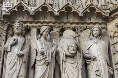 Notre Dame Katedrali, Paris, Fransa 'nın dış duvarlarına Katolik azizlerin karmaşık oymaları. Kanunlardan biri başını elinde tutuyor..
