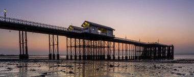 Penarth İskelesi 'nde gün doğumu. Penarth, Galler 'in güney kesiminde, Cardiff yakınlarında, Galler' in başkenti olan bir kıyı kasabasıdır. Rıhtım Viktorya dönemi mimarisinin güzel bir örneği.