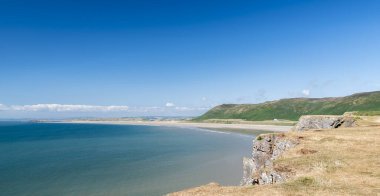Rhossili plajı, körfeze bakan burundan görülüyor. Rhossili, Gower 'da Galler Kıyı Yolu' nda yer almaktadır.