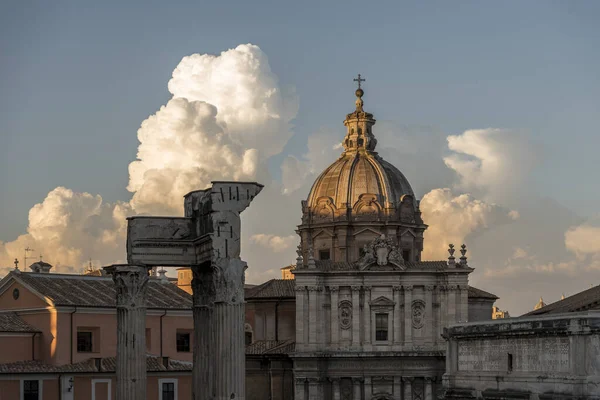 ローマの建物や遺跡 ローマでは 黄色とオレンジで着色された大きな白い雲と深い青い空に対して設定されています — ストック写真