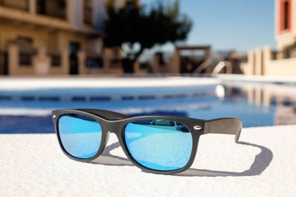 Gafas Sol Azul Espejadas Enmarcadas Negro Posicionadas Lado Una Piscina Fotos De Stock Sin Royalties Gratis