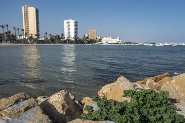 Murcia, İspanya 'daki Mar Menor' un karşısından güneşli bir yaz gününde iki yüksek binaya bakın.