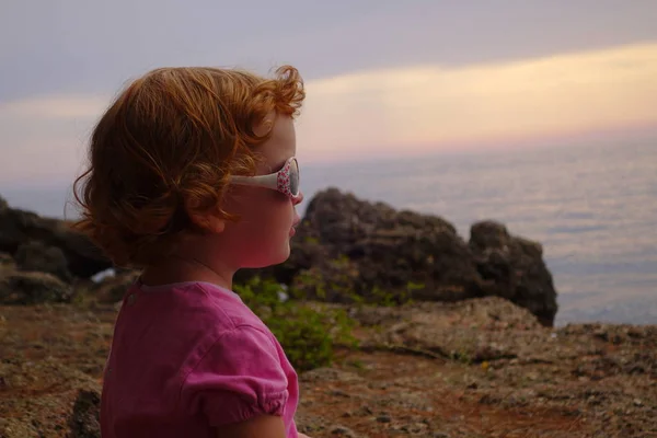 Girl is looking at the sea in sunglasses