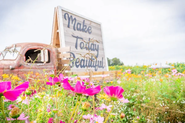 Remolque de tractores antiguos fotografía de utilería en un campo de cultivo de flores junto a flores silvestres, con la cita "hacer hoy hermoso ." — Foto de Stock