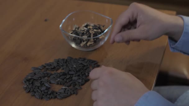Mladý běloch v kuchyni jí slunečnicová semínka během self-izolace karantény — Stock video