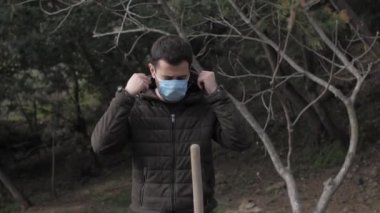 Maskeli beyaz bir adam bahçe karantinasında kendini izole ediyor.