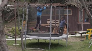 Kız ve erkek trambolinde zıplıyorlar.