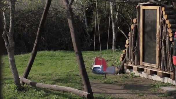 Samotne dziecko huśtawka w podwórku domu — Wideo stockowe
