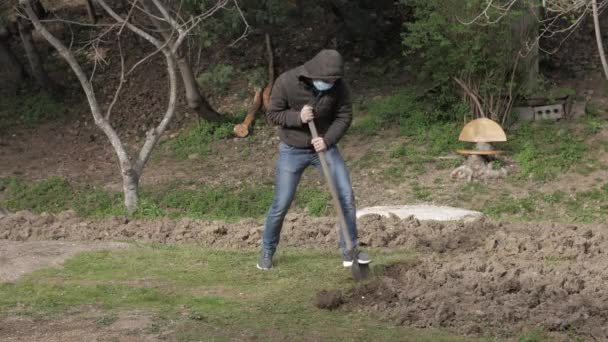 Blank man in masker graven in tuin quarantaine zelf isolatie — Stockvideo