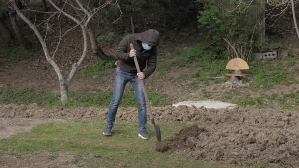 戴面具的高加索人在花园挖掘隔离自我隔离 — 图库视频影像
