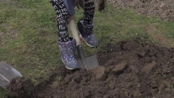 Genç bir çocuk ve kız bahçede kazı yapıyorlar. — Stok video