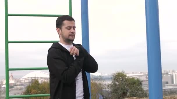 Kaukasisk ung man går in för sport på lekplatsen på en molnig dag — Stockvideo