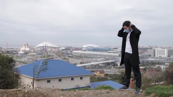 Ung maskerad kille dansar mot bakgrund av staden coronavirus Covid-19 — Stockvideo