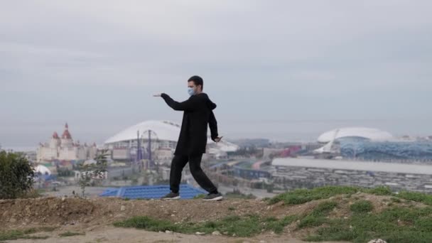 Mladý maskovaný muž tančí na pozadí městského koronaviru Covid-19 — Stock video