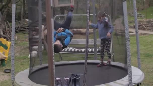 Niño y niña saltando en el trampolín — Vídeos de Stock