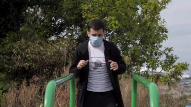 Maskeli genç bir adam spor barlarına gider.