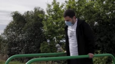 Maskeli genç bir adam spor barlarına gider.