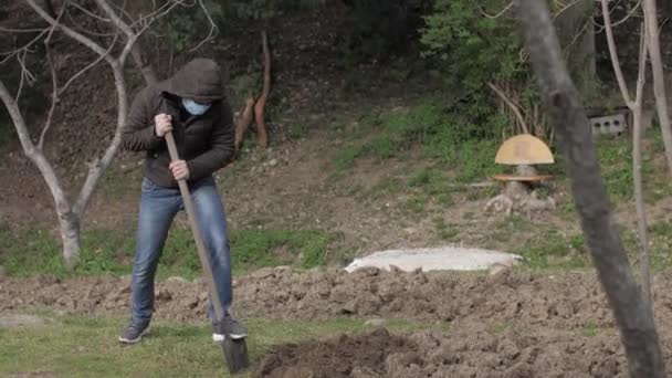 Caucásico chico en máscara excavación en jardín cuarentena auto aislamiento — Vídeo de stock