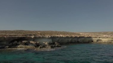 Güneşli bir günde Cape Cavo Greco yakınlarında hava manzaralı mavi göl