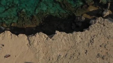 Güneşli bir günde Cape Cavo Greco yakınlarında hava manzaralı mavi göl