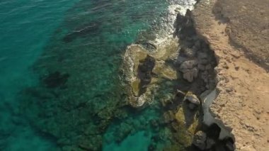 Güneşli bir günde Cape Cavo Greco yakınlarında hava manzaralı mavi göl