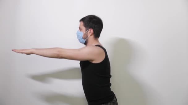 Uomo caucasico in una maschera medica facendo squat sfondo bianco Covid19 Coronavirus — Video Stock