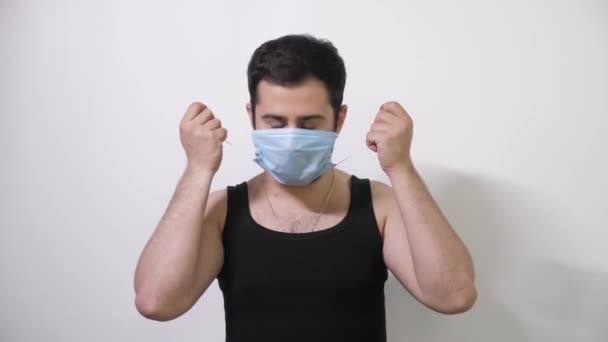 Uomo caucasico in maschera medica fa una mossa interessante guarda nella fotocamera Covid19 Coronavirus — Video Stock