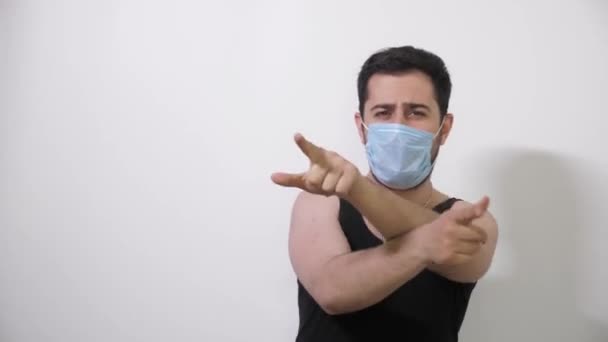 Kaukasische Mann in einer medizinischen Maske tanzen fanny Tanz weißen Hintergrund Covid19 Coronavirus — Stockvideo