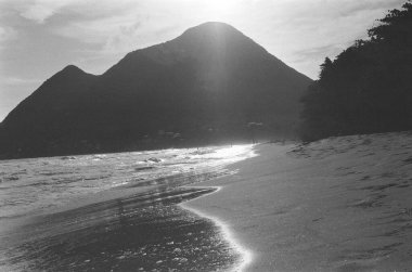 Arkasında volkanik dağlar olan Martinik sahil plajı