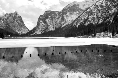 Dolomitlerin ortasındaki karlı dağlar Dobbiaco Gölü 'ne yansıyor.