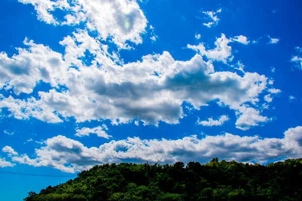 Beyaz Bulutlar Mavi Gökyüzüne Ormanı Lüks Tepelere Karşı Duruyor — Stok fotoğraf