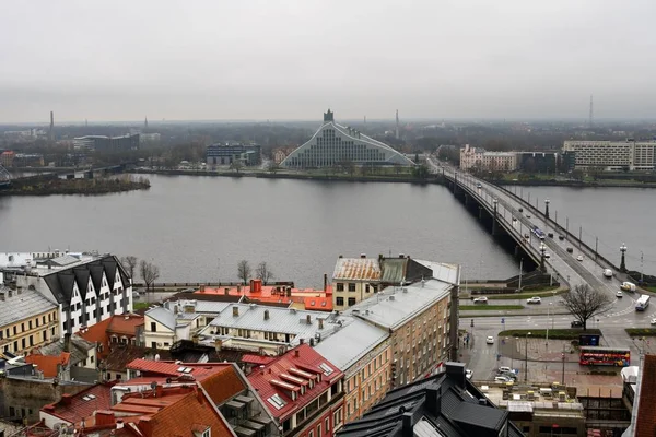 Riga, Letonya, Kasım 2019. Eski şehir, nehir üzerindeki köprü ve ufuktaki ulusal kütüphane..