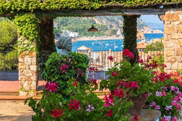 Tossa de Mar, İspanya, Ağustos 2018. Çiçek açan bir bahçenin ortasında antik bir heykelin kopyası..