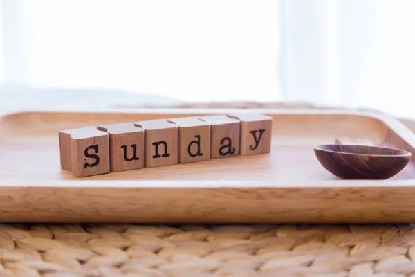 Letters SUNDAY cubes on wooden tray in bedroom. — Stock Photo, Image