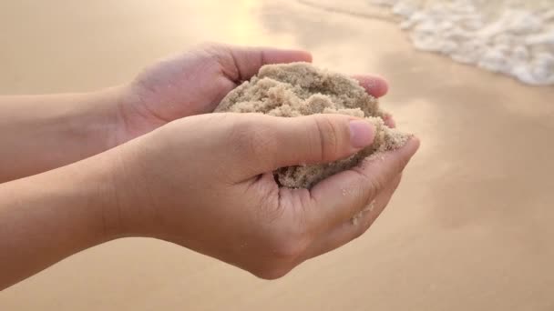 La sabbia che cade dalle mani delle donne sulla spiaggia del tramonto . — Video Stock