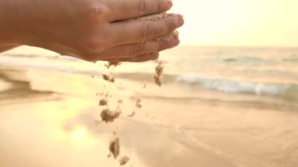 Main de femme avec sable doux tombant sur la plage tropicale . — Video