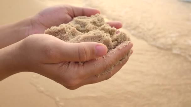 Feminino segurando areia nas mãos na praia . — Vídeo de Stock