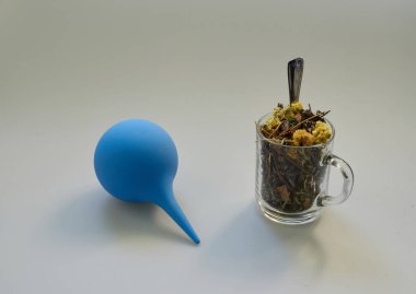 dry herbal tea from different forest herbs in a glass cup and blue syringe syringe on an isolated background. small spoon. towel clipart