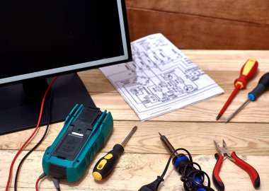Parçalanmış monitör. Elektronik cihazların modern teknik onarımı. Tamir aletleri. Dijital multimetre. Usta tekniğini masaya koy. Elektronik bir cihazın şematik diyagramı.