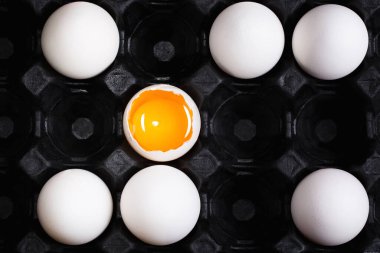 Kırık tavuk yumurtaları siyah arka planda