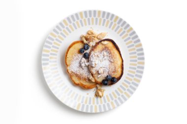 Krep, şeker, yaban mersini, ceviz ve çam fıstığı ile izole edilmiş bir tabakta..