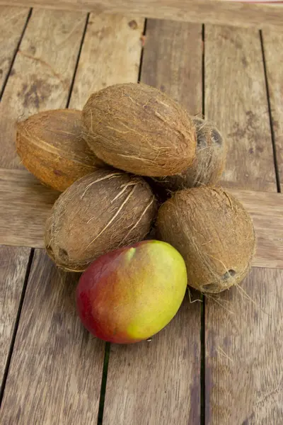 Una Pila Cocos Enteros Mango Mesa Madera Comida Vegetariana Saludable —  Fotos de Stock