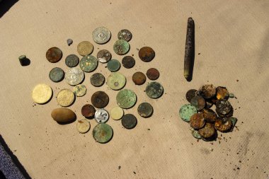 Su altı metal dedektörünün yardımıyla toplanan altın ve gümüş paraların fotoğrafı. Hazine arayışı ve turist macera geçmişi.