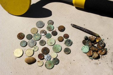 Su altı metal dedektörünün yardımıyla toplanan altın ve gümüş paraların fotoğrafı. Hazine arayışı ve turist macera geçmişi.