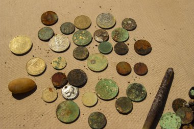 Su altı metal dedektörünün yardımıyla toplanan altın ve gümüş paraların fotoğrafı. Hazine arayışı ve turist macera geçmişi.
