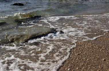 Sıcak kumun yaz arkaplanı deniz veya okyanus kabarcıkları ile fotokopi alanı ile şafak veya gün batımında kart veya reklam için 