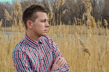 Sazlıkların arka planında profilde genç bir adamın portresi.